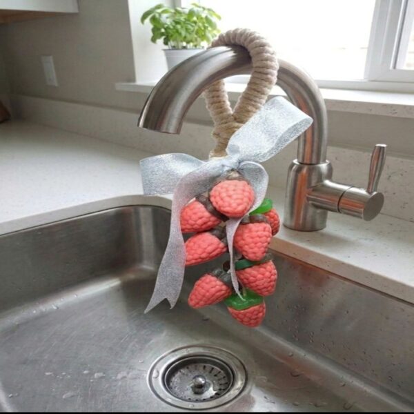 racimo de moras de jabón en el grifo de la cocina